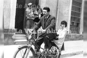 Joaquín Zapata,  vecino de la calle de Granada, atravesando la avenida con su ‘mosquito’ con una niña montada en el portaequipajes.