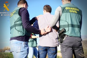 Agentes de la Guardia Civil con un detenido.