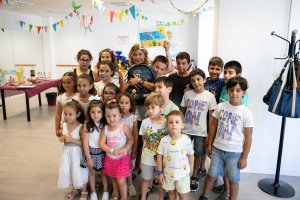 La concejal Paola Laynez posa con los niños que participan en la escuela de verano.