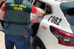 Imagen de un Guardia Civil con un detenido.