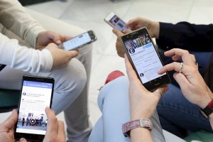 Jóvenes con las redes sociales abiertas en sus smartphone.