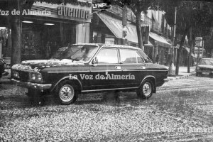 Un taxi pasando por la puerta de la librería Avenida, entre la Puerta de Purchena y el Paseo, en un día de granizada.