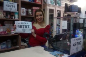 Amanda Miralles muestra el cartel con el cuarto premio vendido en su local.