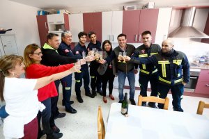 El prersidente de la diputación y la del consorcio brindan con los bomberos.