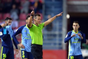 Pulido Santana señala penalti a favor del Numancia después de revisar el VAR.
