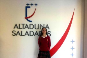 Mónica posa delante del logo de la institución.