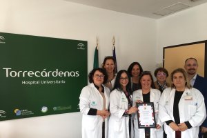 La Unidad de Trabajo Social de Torrecárdenas junto a un representante de la embajada británica con la placa de agradecimiento.