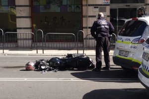 Un agente de Policía Local observa la moto tras el accidente.