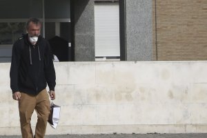 Un hombre con la mascarilla sin colocar sale del Hospital Universitario Virgen del Rocío.