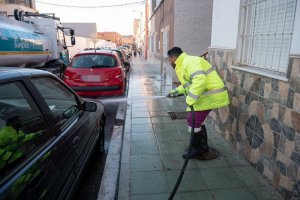 Trabajador baldeando una calle de la ciudad de Almería