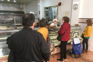 Un sacerdote  y otros clientes haciendo cola ayer en el establecimiento de comidas para llevar de La Juaida en la calle Juan Lirola de la capital.