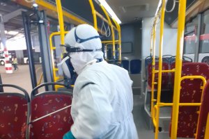 Trabajador desinfectando uno de los autobuses municipales