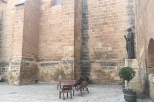 Bancos de la catedral, bajo la estatua del obispo Diego Ventaja, que suelen estar llenos de niños y mayores  y que estos días permanecen desiertos.