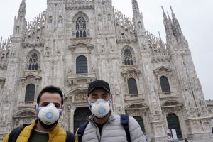 Dos turistas se protegen con mascarillas ante la Catedral de Milán.