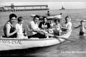La querida familia del restaurante Imperial dando un paseo en barca por la playa de las Almadrabillas con el cargadero al fondo.