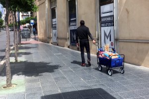Un hombre  con su avituallamiento de alimentos en un carro caminando ayer por la Avenida Pablo iglesias.