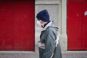 Una persona anda por la calle con mascarilla.