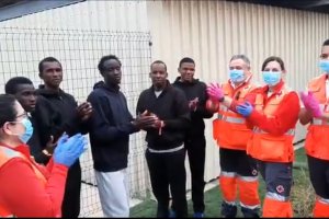 Aplausos a los sanitarios en el área de recepción de inmigrantes en el puerto