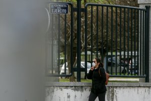 Una mujer pasea con mascarilla por una vía pública.