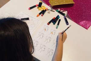 Una niña trabaja en el diseño de sus pendientes usando la plantilla de base.