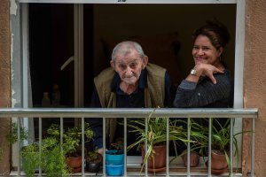 Miguel mira a su enamorada desde su balcón, en compañía de Petrona, su cuidadora.