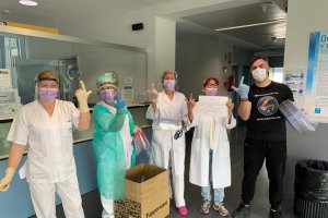 Entregando material a los sanitarios y haciendo el signo de JUSAPOL