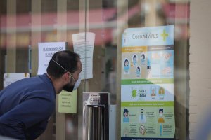 Un hombre consulta recomendaciones en el escaparate de un establecimiento.