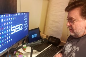 El periodista Alfredo Casas , con buen aspecto, haciendo el programa de radio de la Cadena Ser desde su casa, con juguetes en la mesa.