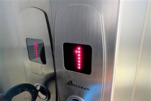 Una persona utiliza la herramienta para pulsar el botón de un ascensor.