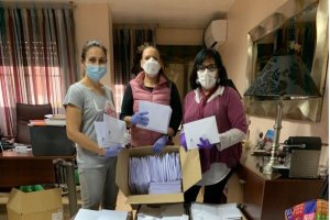 La presidenta del COE (derecha) prepara los envíos de mascarillas junto a personal del Colegio
