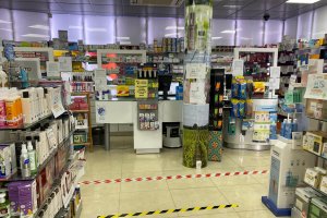 Seguridad con mamparas y líneas para mantener la distancia entre clientes.