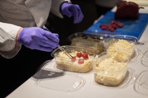 Un cocinero prepara un plato para llevar en un restaurante.