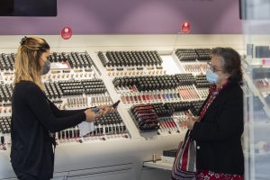 Una empleada de una tienda de cosmética atiende a una clienta.
