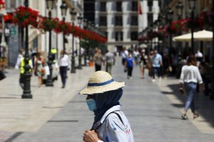Una mujer con mascarilla en las calles de Málaga.