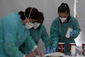 Tres enfermeras trabajan protegidas con mascarillas.