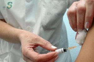 Una sanitaria administra una vacuna a un paciente.