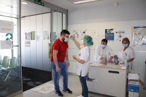 Una profesional toma la temperatura a un paciente.