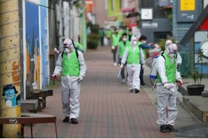 Un grupo de trabajadores desinfectan una calle de Corea del Sur.