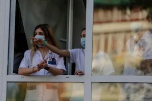 Sanitarios asomados a la ventana de un hospital.
