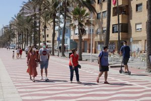 Personas con mascarilla caminando por el Paseo Marítimo de Almería.