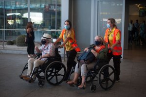 Dos mayores con mascarilla, atendidos a su llegada al aeropuerto de Málaga.
