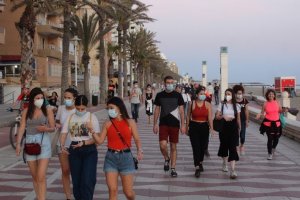 El paseo marítimo de la capital se llena de viandantes con mascarilla.