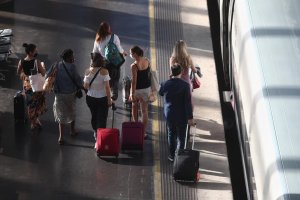 Viajeros caminan por uno de los andenes de la estación de tren Madrid Puerta de Atocha.