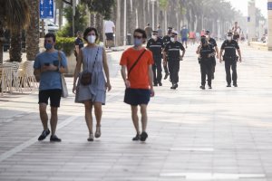 Gente con mascarillas y control policial en Paseo Marítimo de Almería, en el día de ayer.