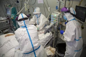 Médicos con EPI tratan a un paciente.