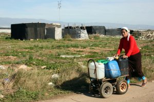 Una mujer transporta agua en asentamientos de chabolas.