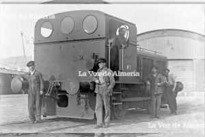 La locomotora ‘Deutz’ y los operarios que la manejaban, en los años 30, posando delante de la nave-factoría que se habilitó en el puerto.
