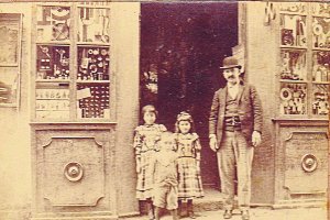 José  Estrade-Berdot en  la puerta de su local de la calle Las Tiendas con sus hijas y el hijo de un tendero vecino. Foto A. Ivorra.