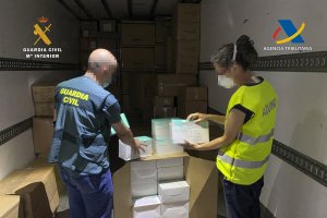 Agentes de la Guardia Civil con las mascarillas intervenidas.