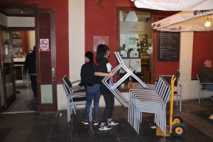 Trabajadores recogiendo las mesas de un establecimiento hostelero